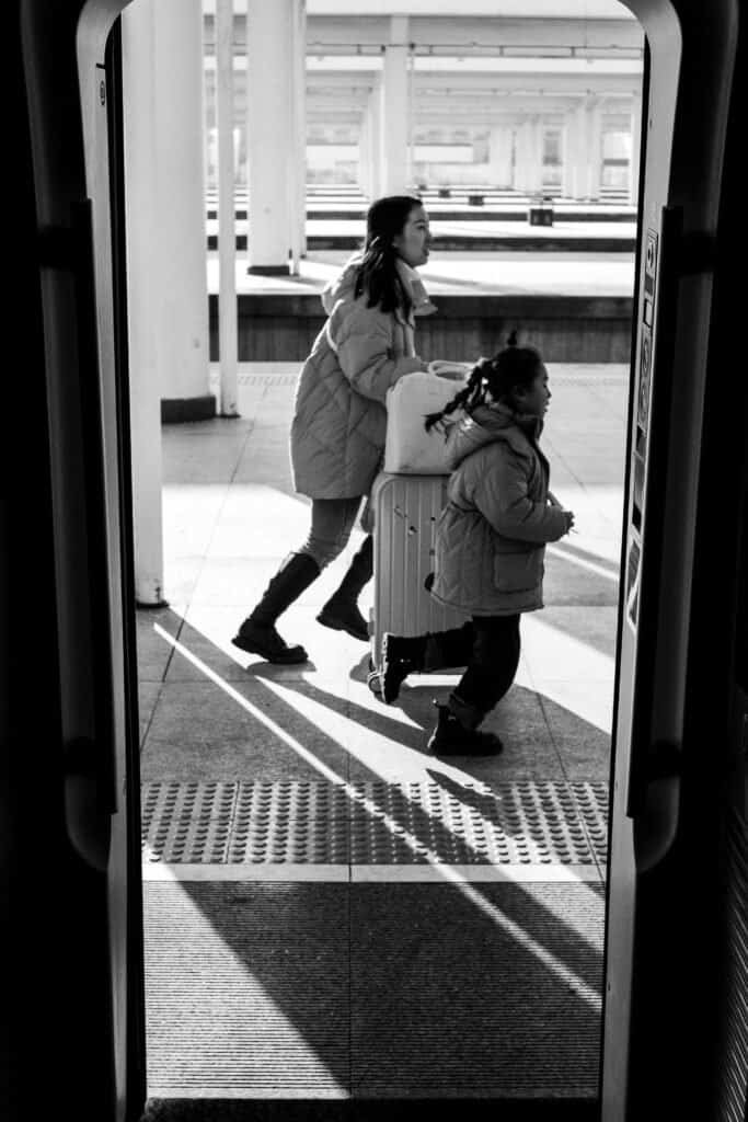 Train station station platform, mother daughter run for their train, black and white, china