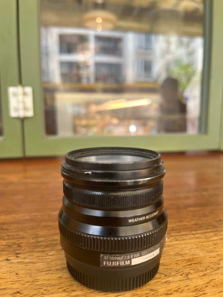 FUJINON XF16mmF2.8 R WR, camera lens, Fuji, 2.8mm, 24mm equivalent, wooden surface, shop, window, small Fuji lens