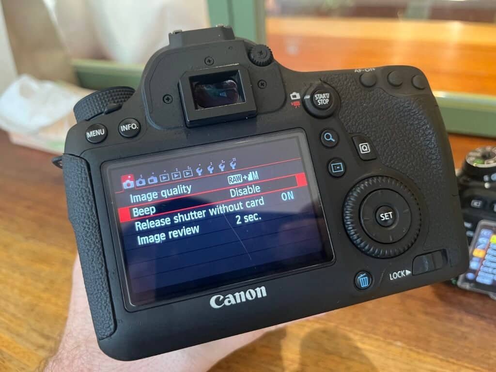 Front view of the canon d6 mark 1 back menu screen side by side with Nikon d600 front
