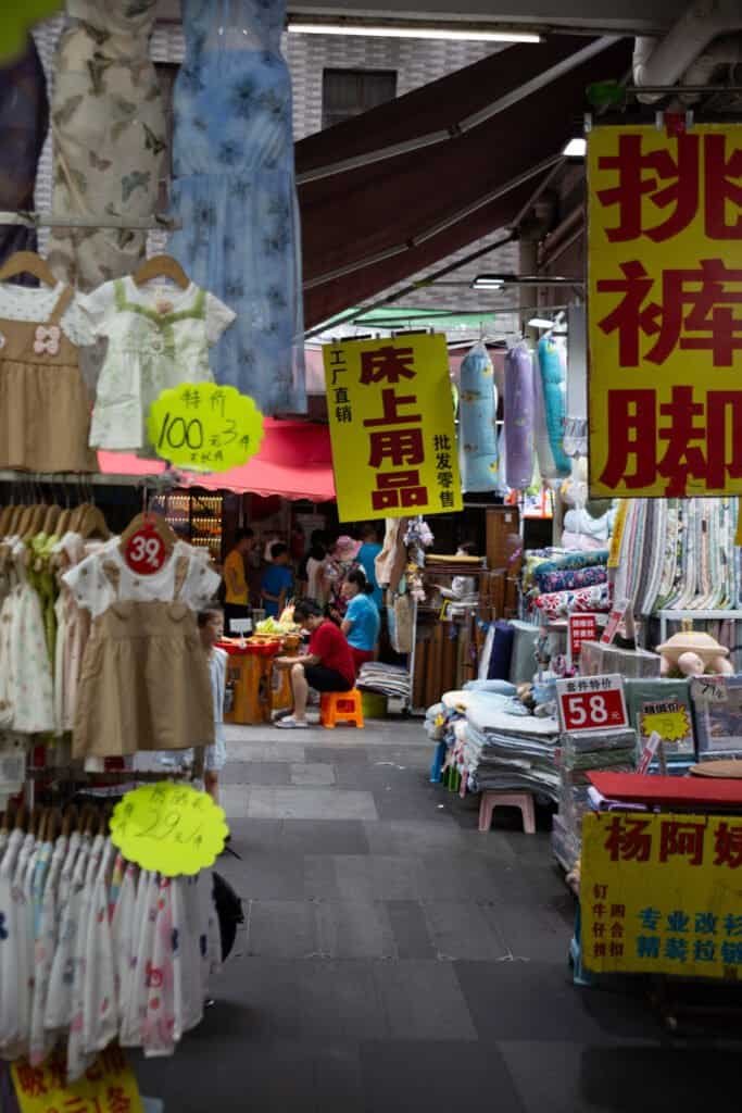 In dongmen Shenzhen china taken on Cannon 6d Mark 1 women selling food clothes shops and signs all around daytime