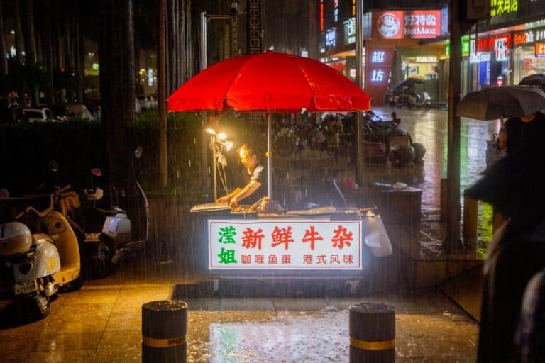 Women sells food rain in low light taken on the canon d6 mark 1 night shuiwei Shenzhen china