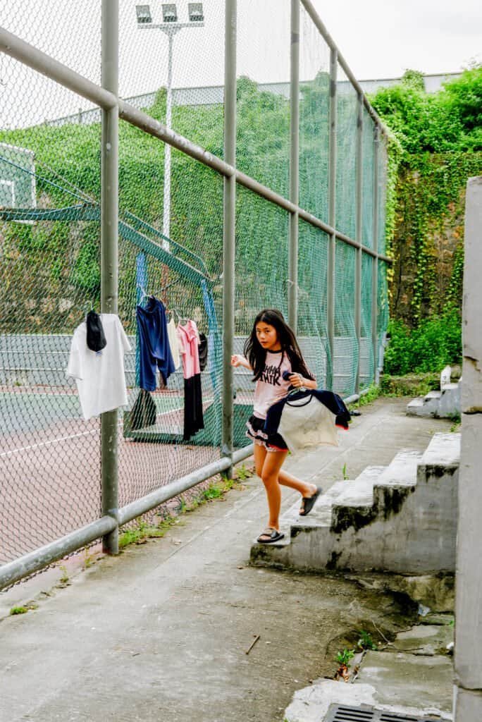 A girl running back home after taking down the laundry in Shenzhen China
