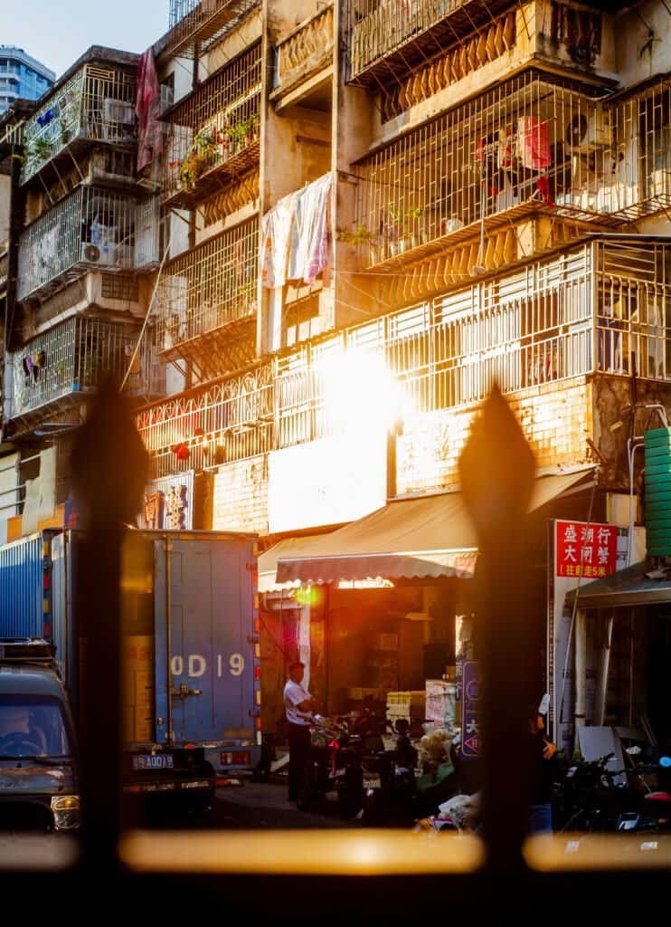 Dongmen Shenzhen china sunset old buildings shot through fence truck man bikes shops sun glaring off balconies Nikon d600