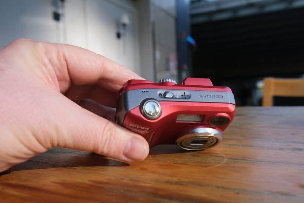 Nikon Coolpix 3200 top view Wooden table hands sunshine chair