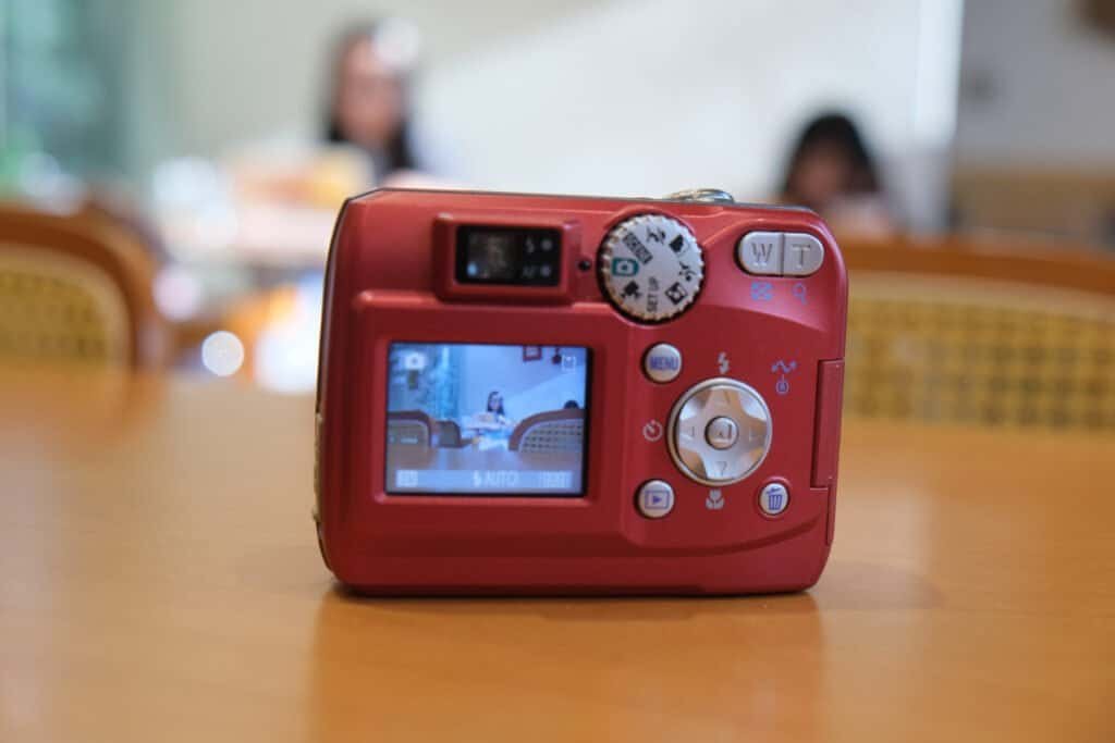 Nikon Coolpix 3200 LCD menu in room light Wooden table hands sunshine chair Girls