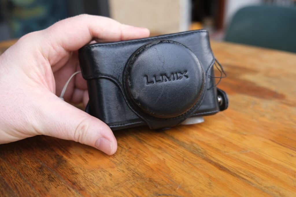 Panasonic LUMiX DMC LX3 in leather case hand table
