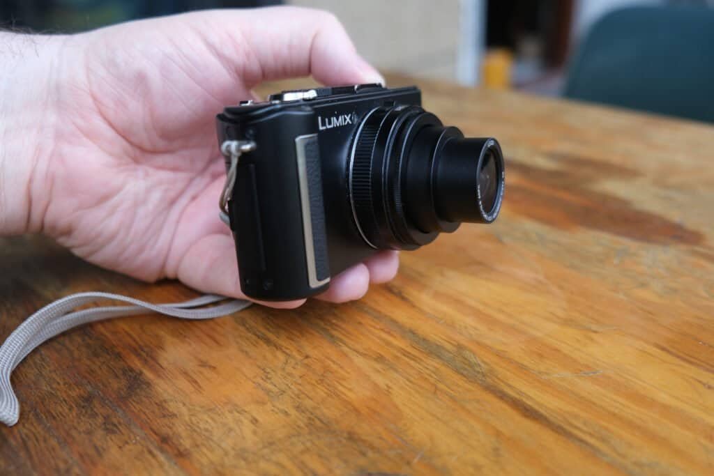 Panasonic LUMiX DMC LX3 in hand table lens cap strap side view lens fully extended
