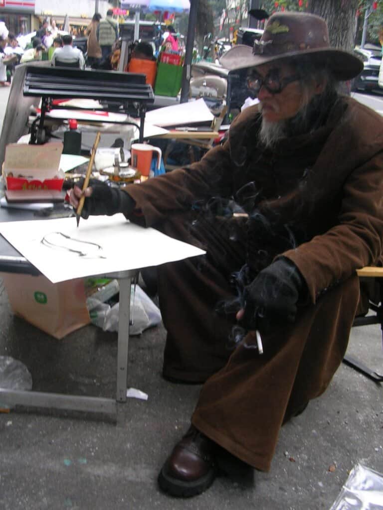 Street painter Chengdu china street paints people daylight hat glasses