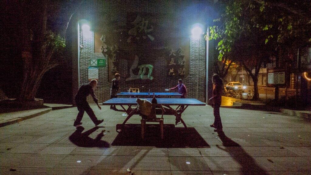 Ping pong at night Chengdu public table street old man woman people china